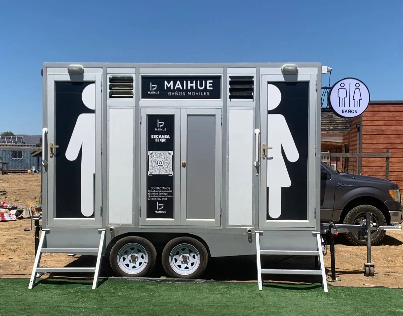 Tráiler de baños móviles premium Maihue instalado sobre césped en un evento al aire libre en Santiago