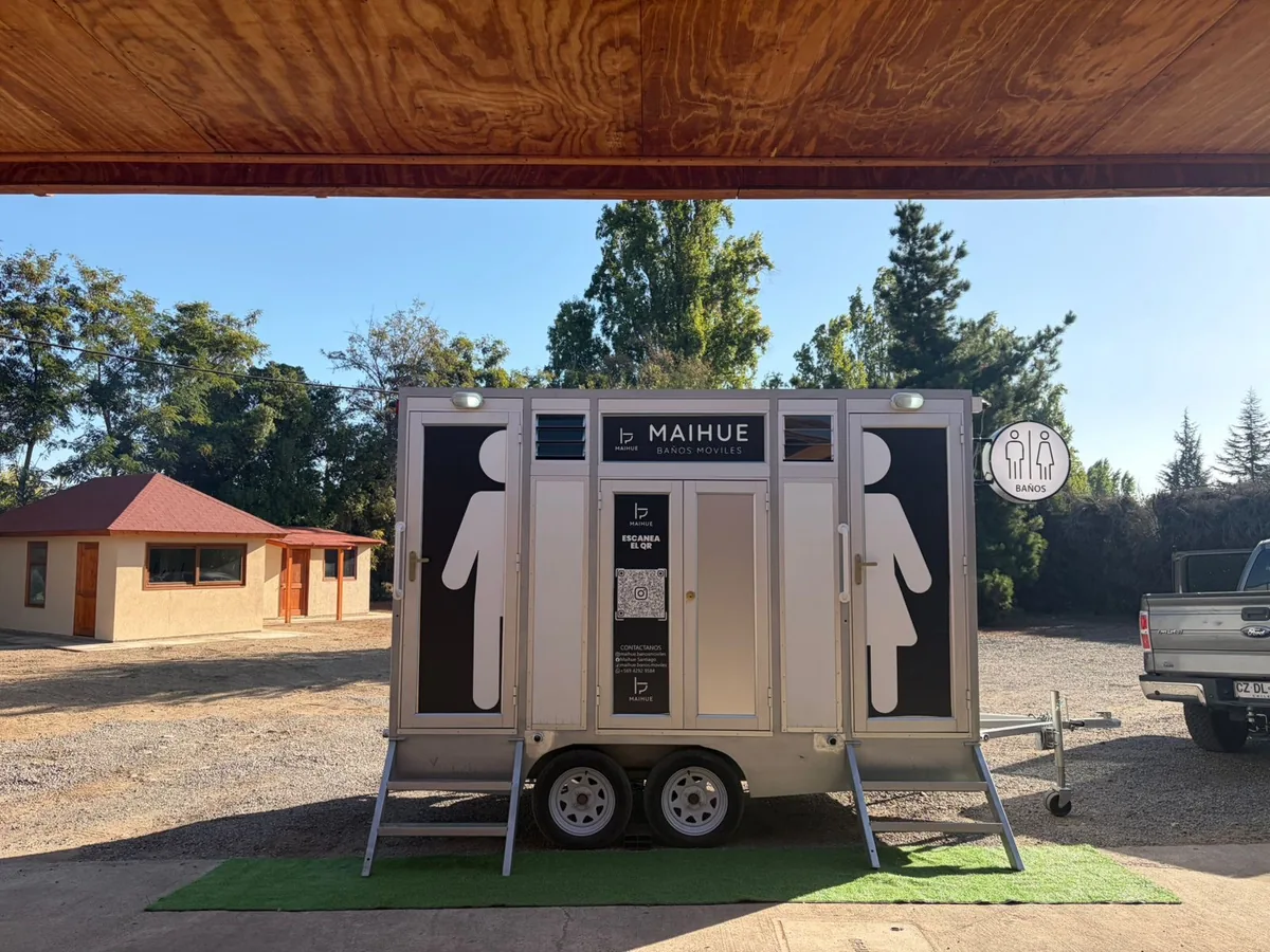 Tráiler baño móvil premium Maihue instalado en una parcela bajo una pérgola
