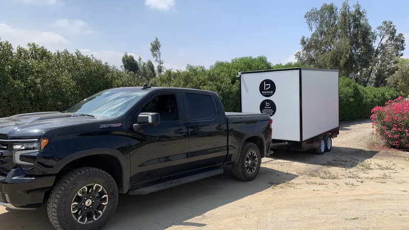 Tráiler baño móvil Maihue en traslado por un camino rural hacia el lugar del evento